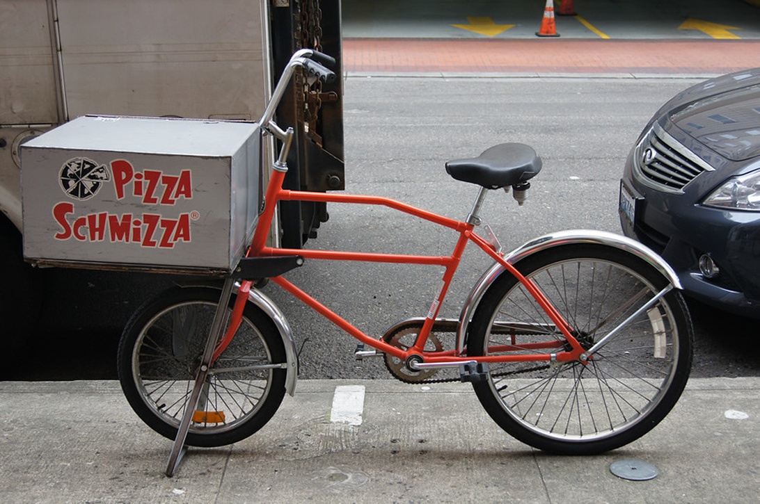 Rode/oranje Pizza Schmizza bezorgfiets met geïsoleerde box.