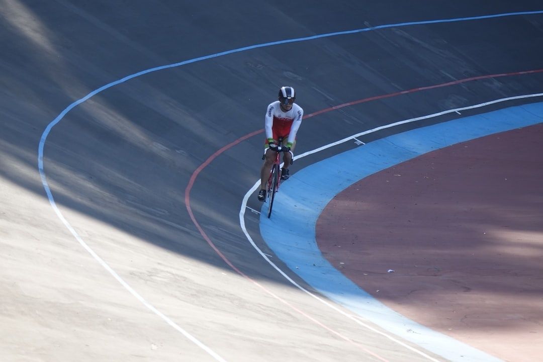 Baanrenner op een vaste fiets in een bocht van de wielerbaan